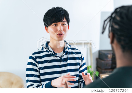 外国人男性と会話する日本人男性 129727294