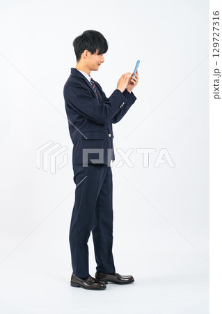 スマホを使う制服を着た男子学生 129727316