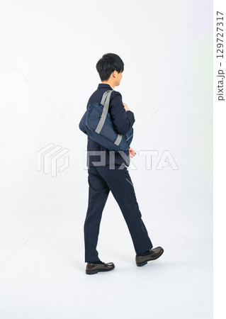 歩く制服を着た男子学生の後ろ姿の全身写真 歩く制服を着た男子学生の後ろ姿の全身写真 129727317