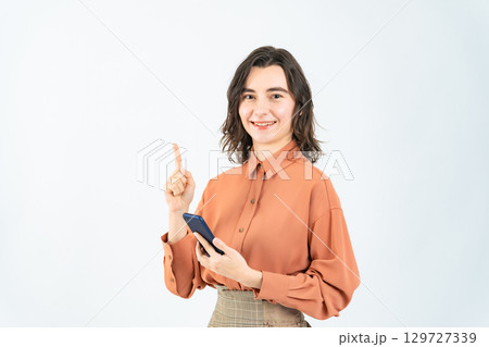 スマホを持って案内する白人女性 129727339