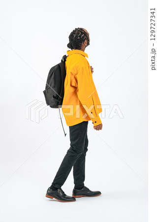 歩きながら上を見上げる黒人男性の全身写真 129727341