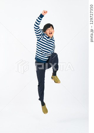 ジャンプするカジュアルな男性の全身写真 129727350