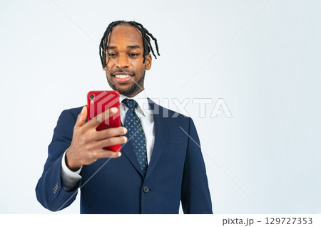 スマホを使う黒人男性ビジネスパーソン スマホを使う黒人男性ビジネスパーソン 129727353