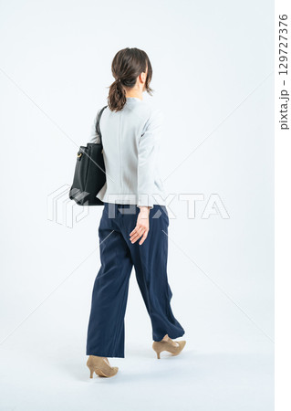 歩く白人女性ビジネスパーソンの全身写真 129727376