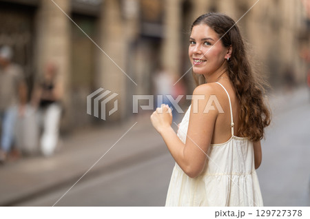Young woman walks along city street Young woman walks along city street 129727378