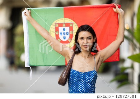 Girl waving Portugal flag on street of summer city Girl waving Portugal flag on street of summer city 129727381