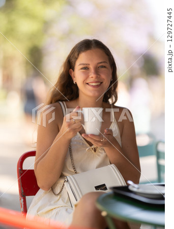 Young woman drinking tea in cafe Young woman drinking tea in cafe 129727445