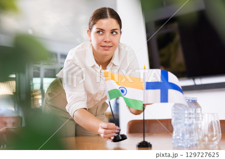 female assistant prepares conference room for diplomats of Finland and India 129727625