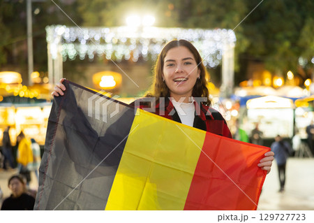Womav waving of the Belgian flag at New Year street fair 129727723