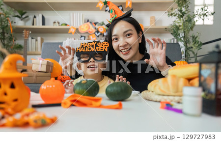 Halloween Celebration. Happy mother and son posing with festive decorations. 129727983