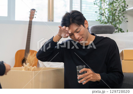 Father taking a break while unpacking, reflecting on family life Father taking a break while unpacking, reflecting on family life 129728020