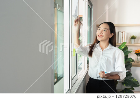 Office Productivity. Young woman organizing workspace and enhancing efficiency. 129728076