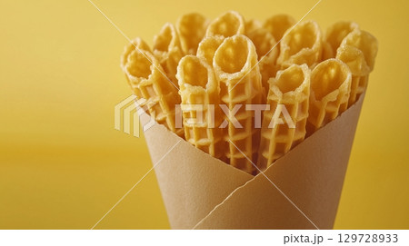 Waffle roll snack crispy wafer stick for kids on paper wrap package solid background 129728933