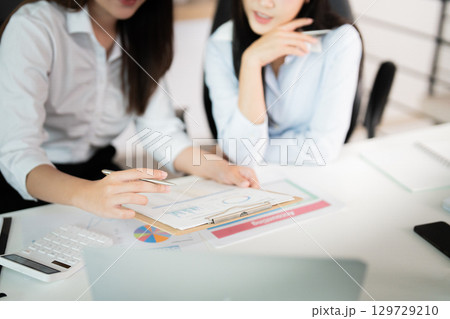 Business Collaboration. Two professionals analyzing financial data in a modern office. Business Collaboration. Two professionals analyzing financial data in a modern office. 129729210