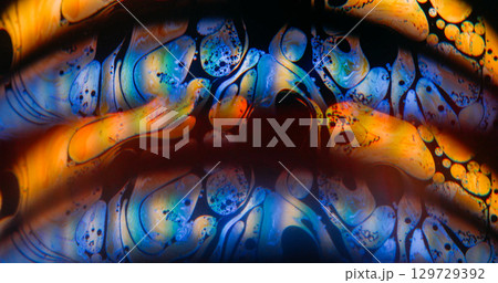 Glow arch blur. Rainbow soap flow. Blue orange duplicated round light lens on black background. Color ink blending abstract liquid. Glow arch blur. Rainbow soap flow. Blue orange duplicated round light lens on black background. Color ink blending abstract liquid. 129729392