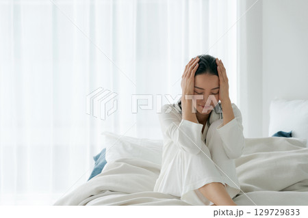 疲れた表情で起きる女性 129729833