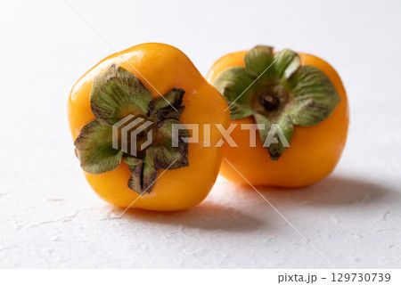 Fresh ripe persimmon on white background, Autumn sweet fruit 129730739