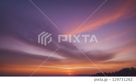 A stunning sunset over the ocean, with vibrant colors and wispy clouds, creates a beautiful scene 129731262