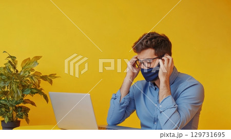 man working from home wearing a face mask 129731695