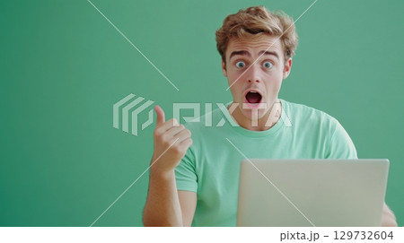 surprised man with laptop giving thumbs up 129732604