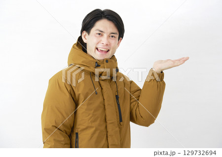 ダウンジャケットを着た男性 右側を手のひらで指す 白背景 ダウンジャケットを着た男性 右側を手のひらで指す 白背景 129732694