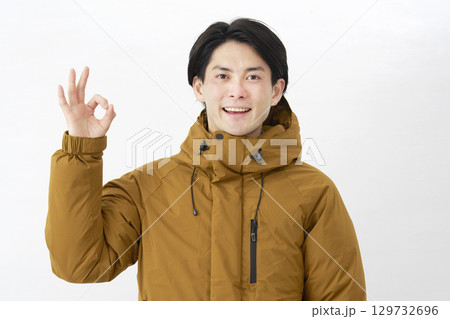 ダウンジャケットを着た男性 OKサイン 白背景 ダウンジャケットを着た男性 OKサイン 白背景 129732696