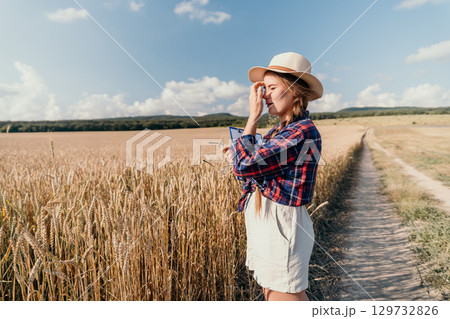 Woman in a Wheat Field, Examining Crop with Clipboard 129732826