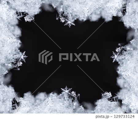 Macro snowflakes showing intricate winter details on dark background Macro snowflakes showing intricate winter details on dark background 129733124