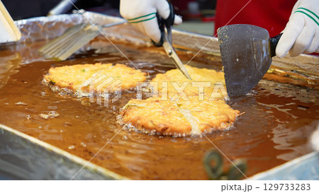 市場の屋台で緑豆チヂミを焼いているシーン 129733283