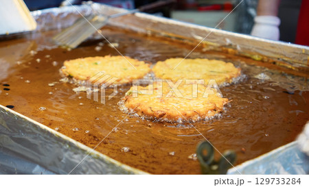 市場の屋台で緑豆チヂミを焼いているシーン 市場の屋台で緑豆チヂミを焼いているシーン 129733284