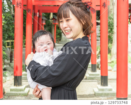【お母さんとお宮参りの赤ちゃんと赤い鳥居】 129733748