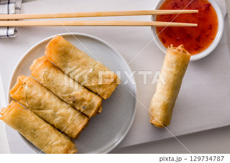 Fried spring rolls with sweet and saur sauce on white table. Top view. 129734787