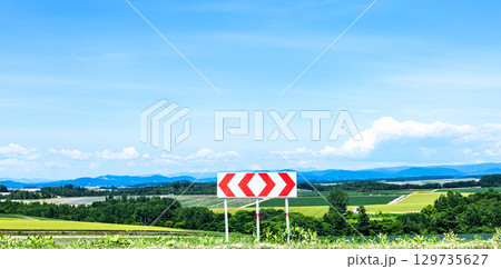 青空が広がる夏の北海道の風景と左右に分かれる分岐標識 129735627