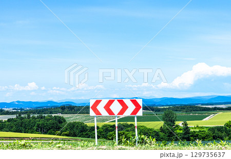 青空が広がる夏の北海道の風景と左右に分かれる分岐標識 青空が広がる夏の北海道の風景と左右に分かれる分岐標識 129735637
