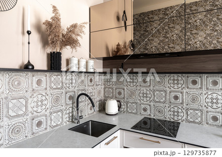 Close-Up of Stylish Kitchen Counter with Patterned Tiles 129735877