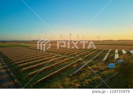 Solar panels and wind turbines at sunset. Renewable energy production Solar panels and wind turbines at sunset. Renewable energy production 129735979