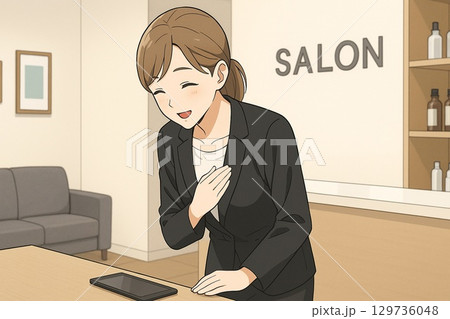 サロン受付で微笑みながらお客様を迎える女性スタッフ 129736048