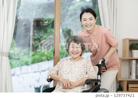 車椅子に座るシニア女性を介護する介護士 129737421