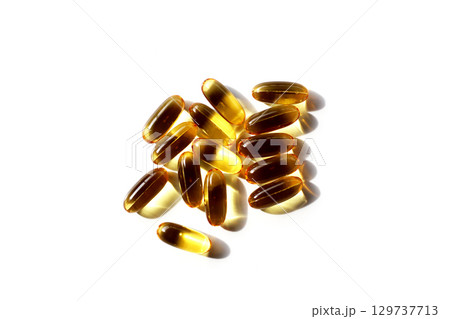 Golden fish oil capsules on white background. Golden fish oil capsules on white background. 129737713