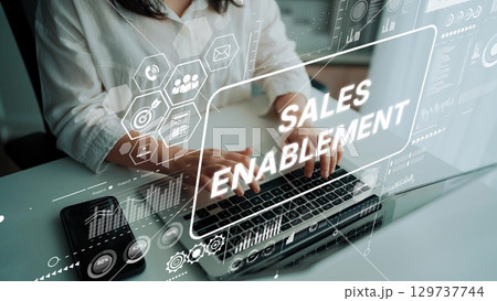 Woman Engaged in Sales Enablement Strategy with Digital Overlays of Data and Analytics on Keyboard in Modern Workspace. Asymptotic smart data analytic 129737744