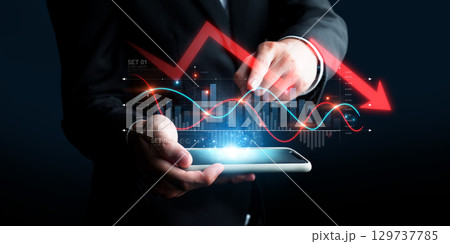 Businessman Holding Tablet with Economic Crisis Data, Graphs Showing Downtrend, Indicating Bankruptcy Risks and Market Volatility in Modern Digital Environment XDMCP 129737785