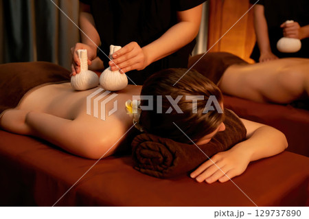 Hot herbal ball spa massage body treatment with couple customer. Quiescent Hot herbal ball spa massage body treatment with couple customer. Quiescent 129737890