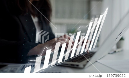 Businesswoman Using Laptop with Financial Graph Overlay in Modern Office Setting for Professional Growth and Investment Planning Copula Businesswoman Using Laptop with Financial Graph Overlay in Modern Office Setting for Professional Growth and Investment Planning Copula 129739022