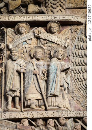 Intricate stone carvings depicting Biblical scenes at the entrance of a historic church in Conques, France 129740629