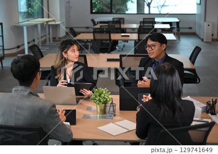 Professional colleagues discussing project details in a modern office 129741649