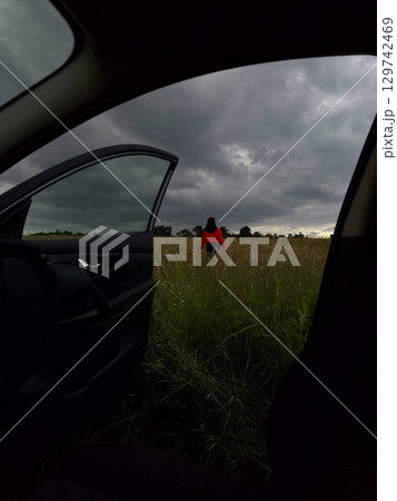 Person in Red Jacket Standing in Field 129742469