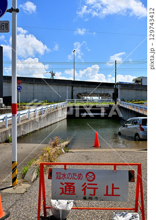 大雨の影響で冠水し通行止めになったアンダーパス道路 129743412