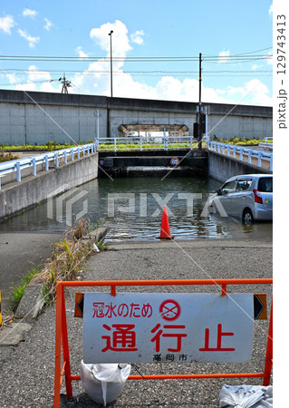 大雨の影響で冠水し通行止めになったアンダーパス道路 129743413