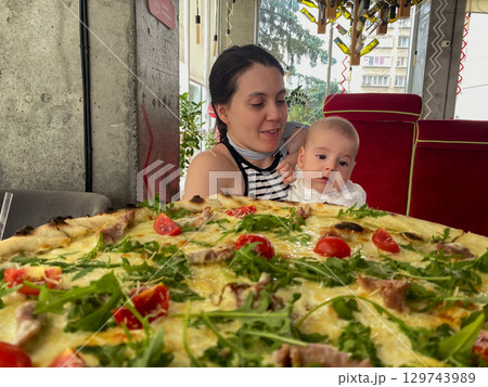 Mother and Baby Enjoying Pizza at a Restaurant 129743989