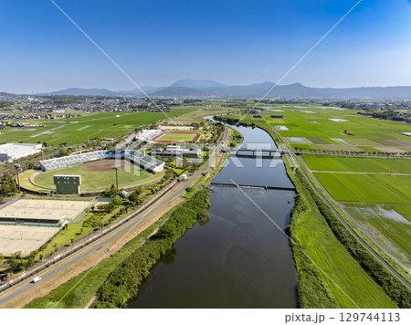 ドローン空撮した小郡市陸上競技場、野球場、川と水田 ドローン空撮した小郡市陸上競技場、野球場、川と水田 129744113